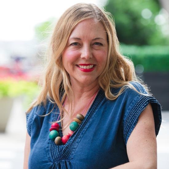 Headshot of Alissa Walker in a blue dress and beaded necklace against an outdoor setting. Image courtesy of Alissa Walker.